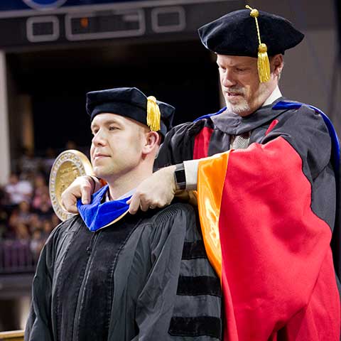 Graduate Student being hooded at the 2019 Commencement Ceremony.